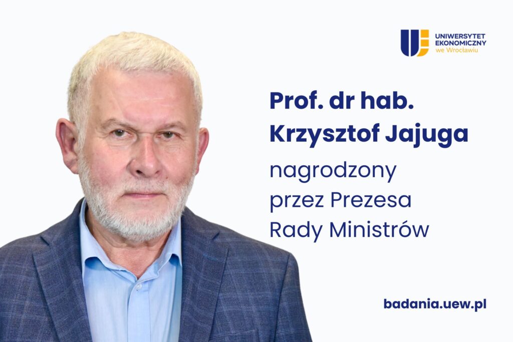 Mężczyzna w granatowym garniturze na białym jednolitym tle, obok napis "Prof. dr hab. Krzysztof Jajuga nagrodzony przez Prezesa Rady Ministrów"