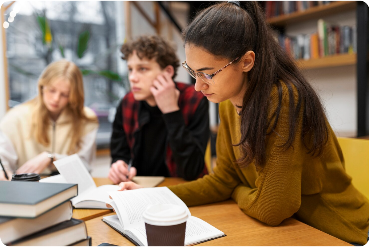 Grupa studentów podczas wspólnej nauki w bibliotece.